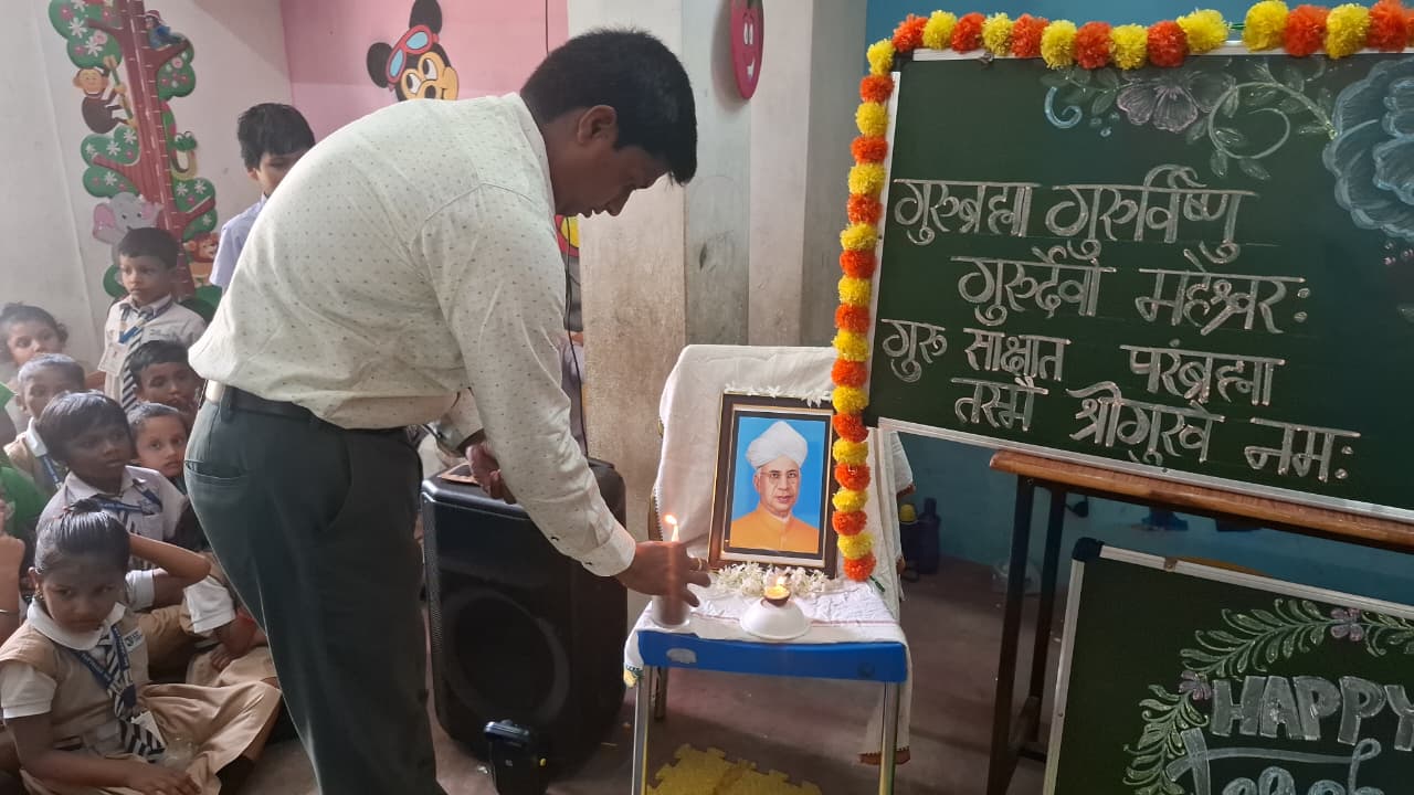 A teacher lighting a lamp on Teacher’s Day as Bal Vidyalaya children watch