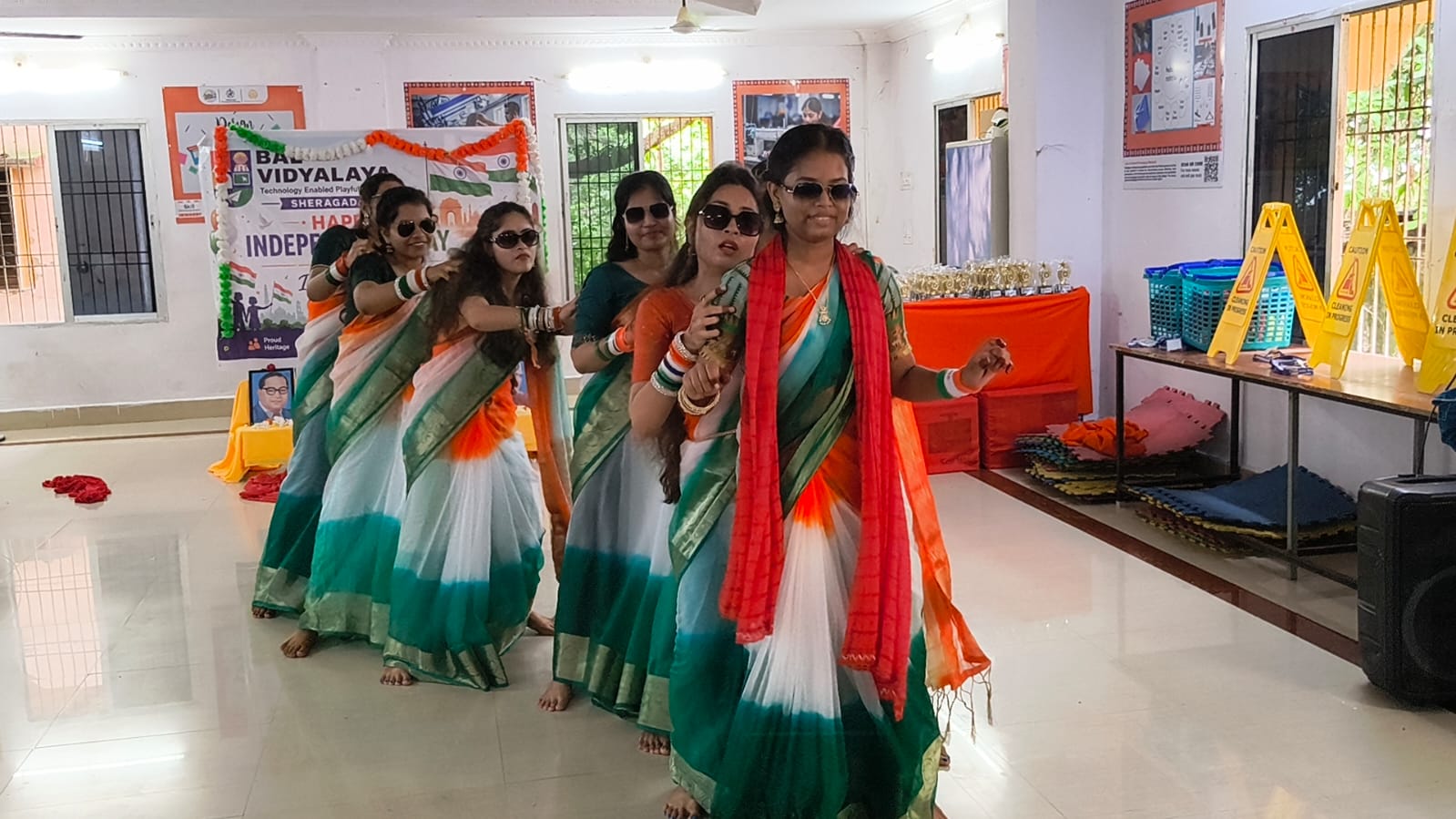 Staff dancing in a line before the Happy Independence Day banner
