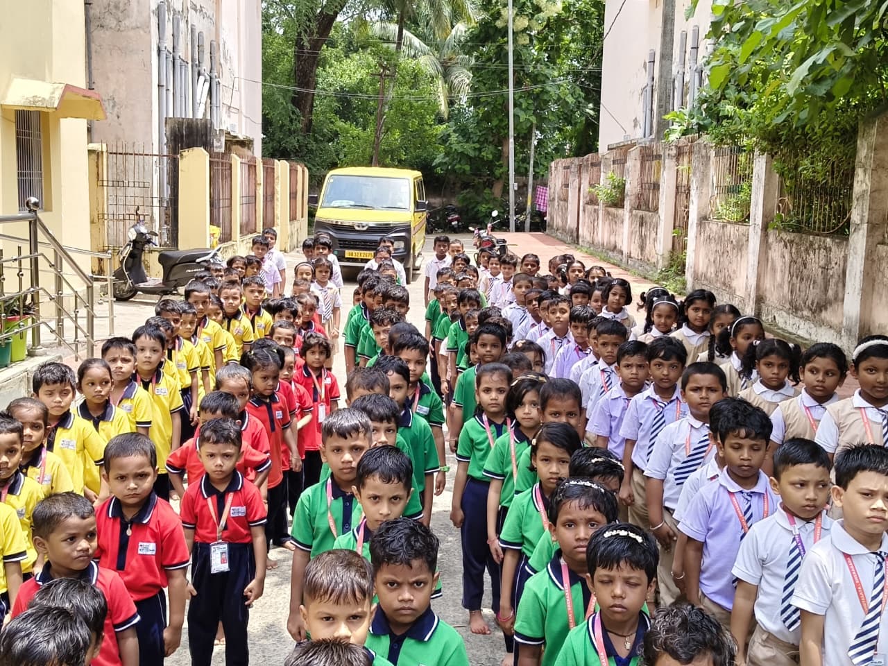 Children lined up outdoors in house-colour uniforms